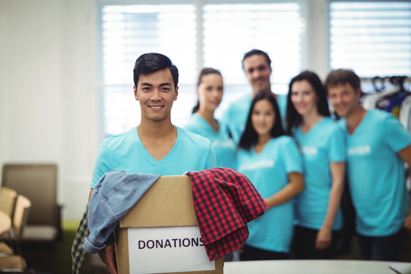volunteer holding clothes in donation box